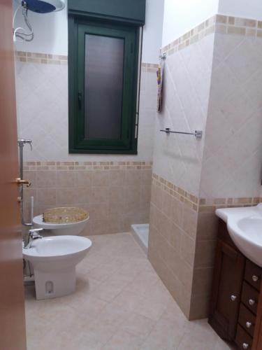a bathroom with a toilet and a sink and a shower at Villa Angela in Marinella di Selinunte