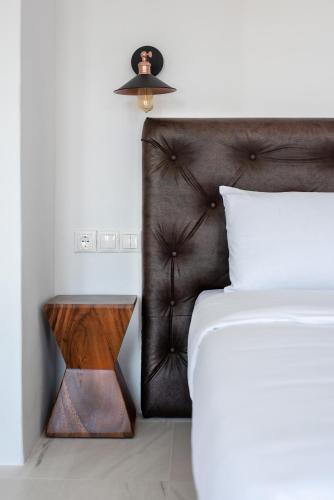 a bedroom with a bed and a table with a lamp at Etesians Suites & Villas in Super Paradise Beach