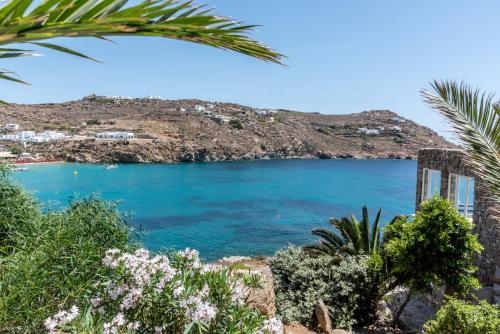 a view of a blue lake with a hill in the background at Etesians Suites & Villas in Super Paradise Beach