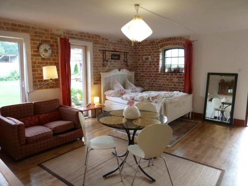 - un salon avec un canapé, une table et un lit dans l'établissement Guest House Wiejska Sielanka, à Brody