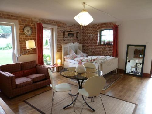 a living room with a couch a table and a bed at Guest House Wiejska Sielanka in Brody