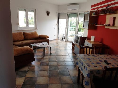 ein Wohnzimmer mit einem Sofa und einem Tisch in der Unterkunft Apartment-Villa Vesna in Privlaka