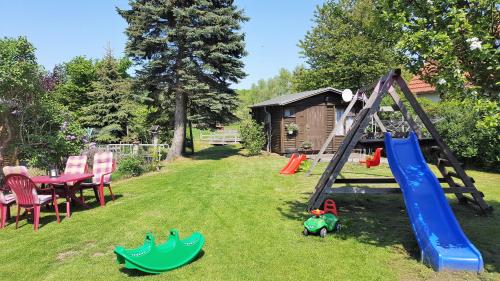 a playground with a slide and play equipment in a yard at Urlaub beim Schmied in Kühlungsborn
