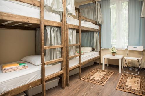 モスクワにあるLenin Hostelの二段ベッド2台、テーブルが備わる二段ベッドルームです。