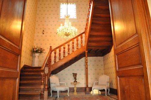 a staircase in a home with a chandelier at Château Logis de Roche in Clairac
