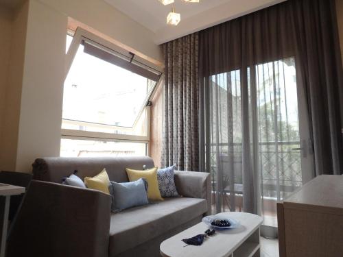 a living room with a couch and a large window at Lion Apartment Sunset in Thessaloniki