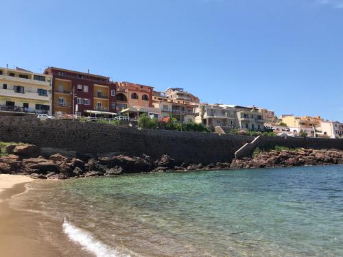 a view of a beach with buildings in the background at Il doppio nodo in Castelsardo