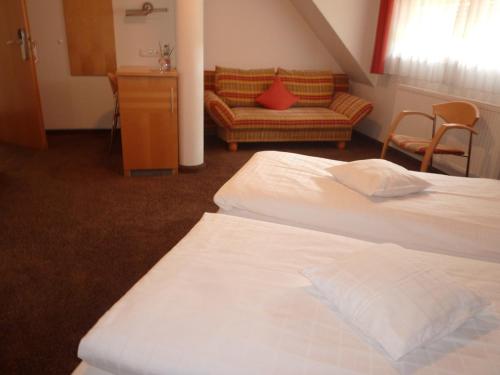 a hotel room with two beds and a couch at Gasthof zum Bad in Langenau