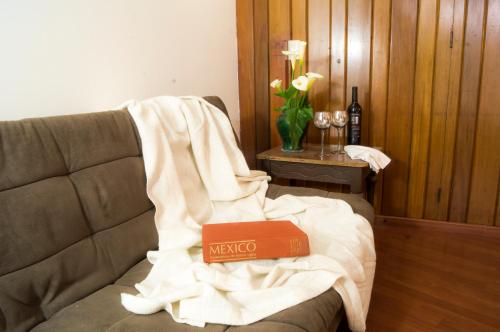 a book sitting on a couch with a blanket on it at Suite 1C, Balcon, Garden House, Welcome to San Angel in Mexico City