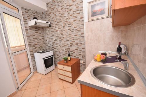 a small kitchen with a sink and a stove at Grifone Igalo in Herceg-Novi