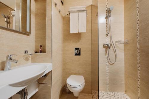 duas imagens de uma casa de banho com WC e chuveiro em Helix Hotel em Sochi