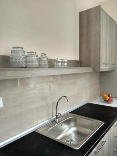 a kitchen with a sink and a shelf with jars at Skiron House in Skala Kallirachis