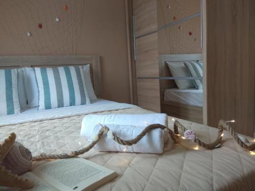 a bedroom with a bed with a book and lights at Skiron House in Skala Kallirakhis
