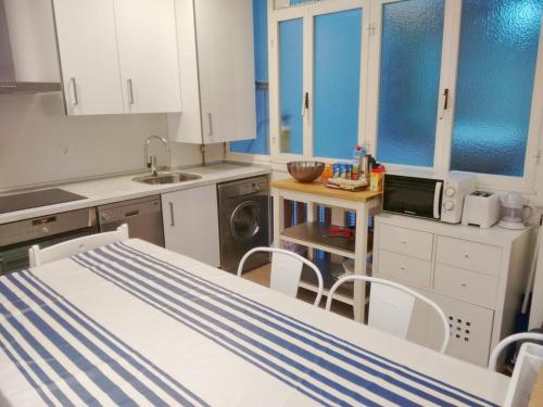 una cocina con armarios blancos y una cama en una habitación en Heriz 8, en San Sebastián