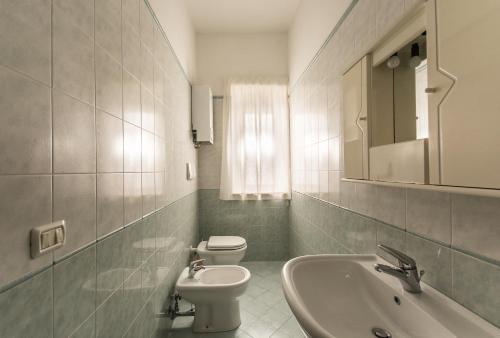 a white bathroom with a toilet and a sink at Residenza Piccolo Uliveto in San Menaio