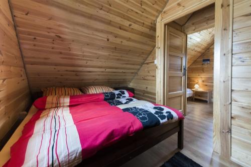 a bedroom with a bed in a wooden cabin at Domek w sercu Kaszub in Sominy