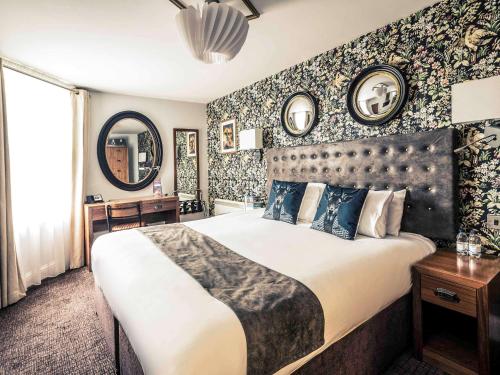 a bedroom with a large bed and floral wallpaper at Mercure Nottingham City Centre Hotel in Nottingham