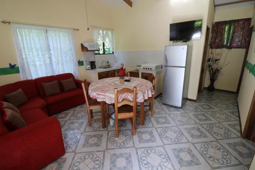 a living room with a table and a red couch at New Caribe Point in Cahuita