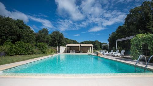 une piscine avec des chaises et un gazebo dans l'établissement Mas Saint Antoine, à Bourg-Saint-Andéol