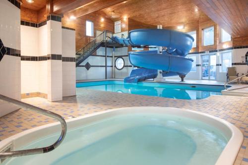a large tub with a slide in a swimming pool at Travelodge by Wyndham Golden Sportsman Lodge in Golden