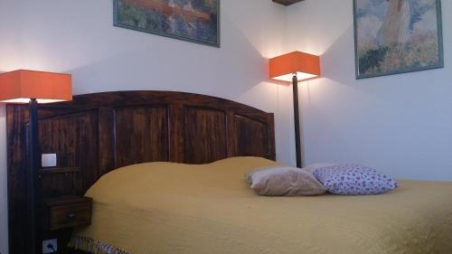 um quarto com uma cama com 2 almofadas e 2 candeeiros em Chambres et Tables d'Hotes "Au pres de ma Blonde" em Senouillac