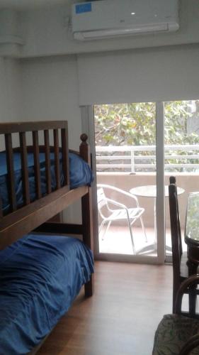 1 dormitorio con litera y balcón con silla en Tu Espacio en La Plata