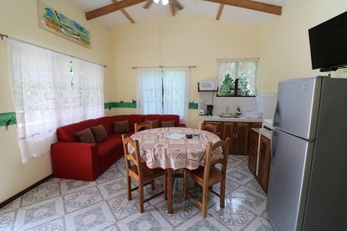 a living room with a table and a red couch at New Caribe Point in Cahuita