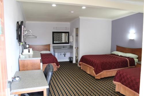 Habitación de hotel con 2 camas y mesa en Trails Motel, en Lone Pine