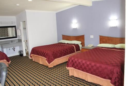 a hotel room with two beds and a flat screen tv at Trails Motel in Lone Pine