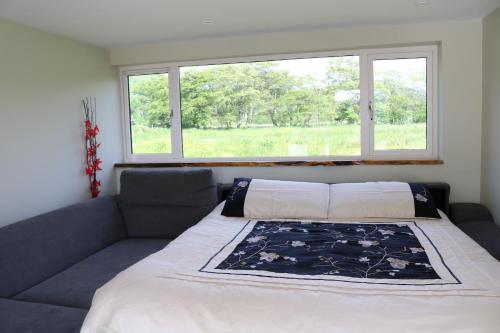a bedroom with a large bed with a window at Creaggan Ard Guest House in Kyle of Lochalsh