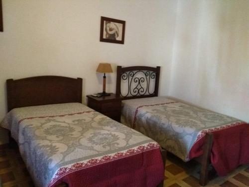 Habitación con 2 camas y mesa con lámpara. en Residencial Sorriso, en Sousel