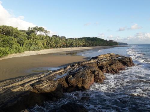 an empty beach with a rock in the water at Las Brisas del Sur in Ojochal