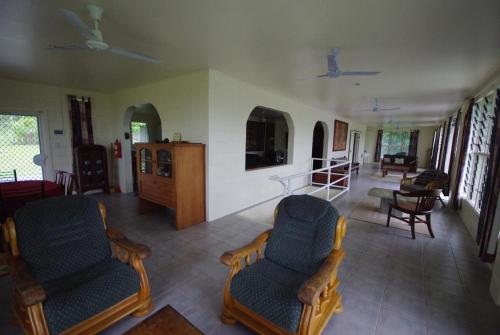 a living room with two chairs and a table at Samoan Highland Hideaway in Siusega