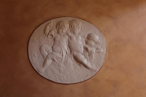 a silver coin with three children on a wall at Hotel Il Santuario - Pompei in Pompei