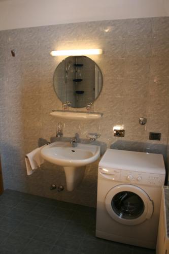a bathroom with a washing machine and a sink at Gasthof Majestic in Bressanone