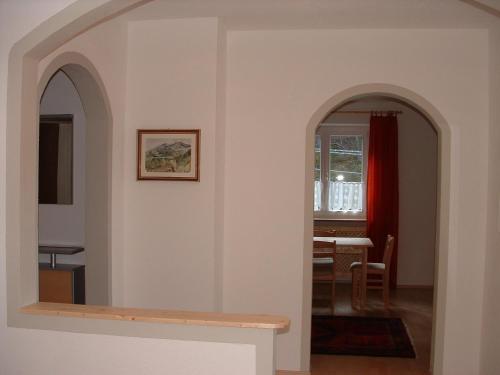 an archway leading into a dining room with a table at Gasthof Majestic in Bressanone