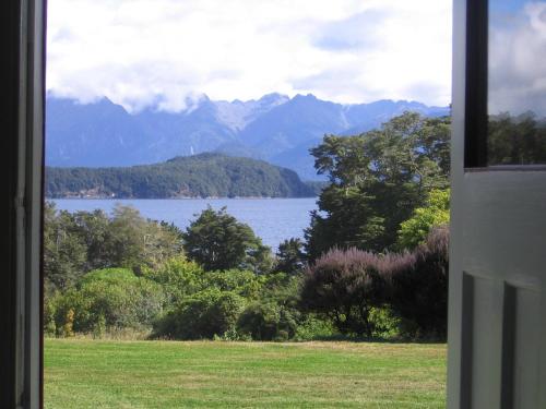 a view of a lake and mountains from a window at Murrells Grand View House in Manapouri