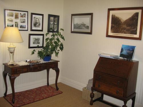 a room with a desk and a table with a laptop on it at Murrells Grand View House in Manapouri