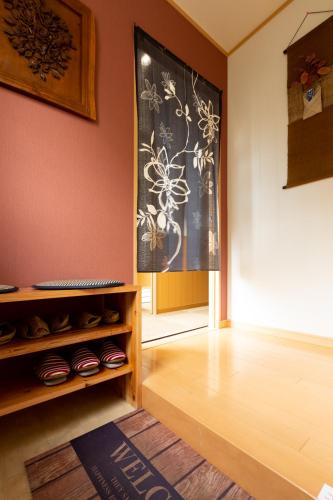 a room with a wall with a painting of flowers at ABC Guest House 2F in Izumi-Sano