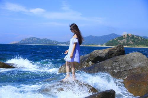 a young girl standing on a rock in the water at Aloha Bình Tiên-Thôn Bình Tiên, Công Hải, Thuận Bắc, Ninh Thuận, Việt Nam in Phan Rang