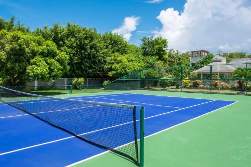 a tennis court with a net on it at Mais Oui Villa in Discovery Bay