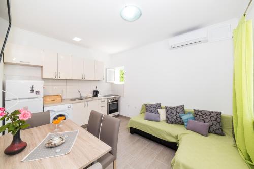 eine Küche und ein Wohnzimmer mit einem Tisch und einer Couch in der Unterkunft Apartment Nane in Trogir