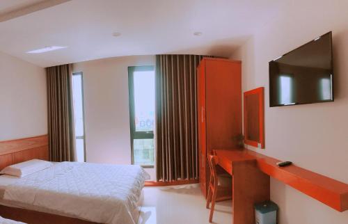 a bedroom with a bed and a desk and a television at Mỹ Ngọc Hotel in Can Tho