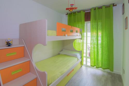 ポルトシンにあるApto Playa de Coiraの小さなベッドルーム(緑のカーテン付きの二段ベッド付)