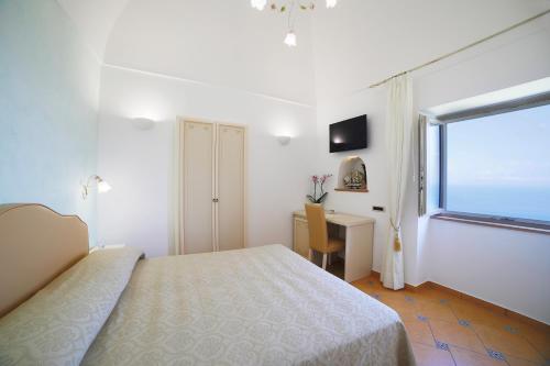 - une chambre avec un lit, un bureau et une fenêtre dans l'établissement L'Angolo dei Sogni, à Ravello