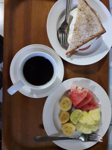 una mesa con dos platos de comida y una taza de café en Tanaya Homestay en Amed