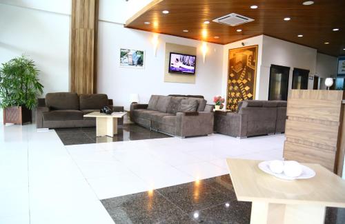 a lobby with couches and tables in a building at Swamy Hotel in Cruzeiro do Sul