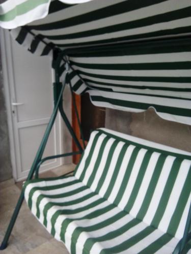 a black and white striped chair sitting under a bed at Best Host in Sighnaghi