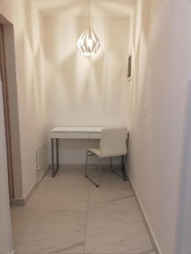 a table and a chair in a hallway with a light at Apartment Marko in Rovinjsko Selo