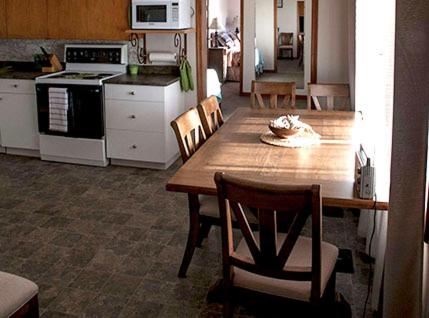 a kitchen with a wooden table and a table and chairs at Marge's Manor in Sooke